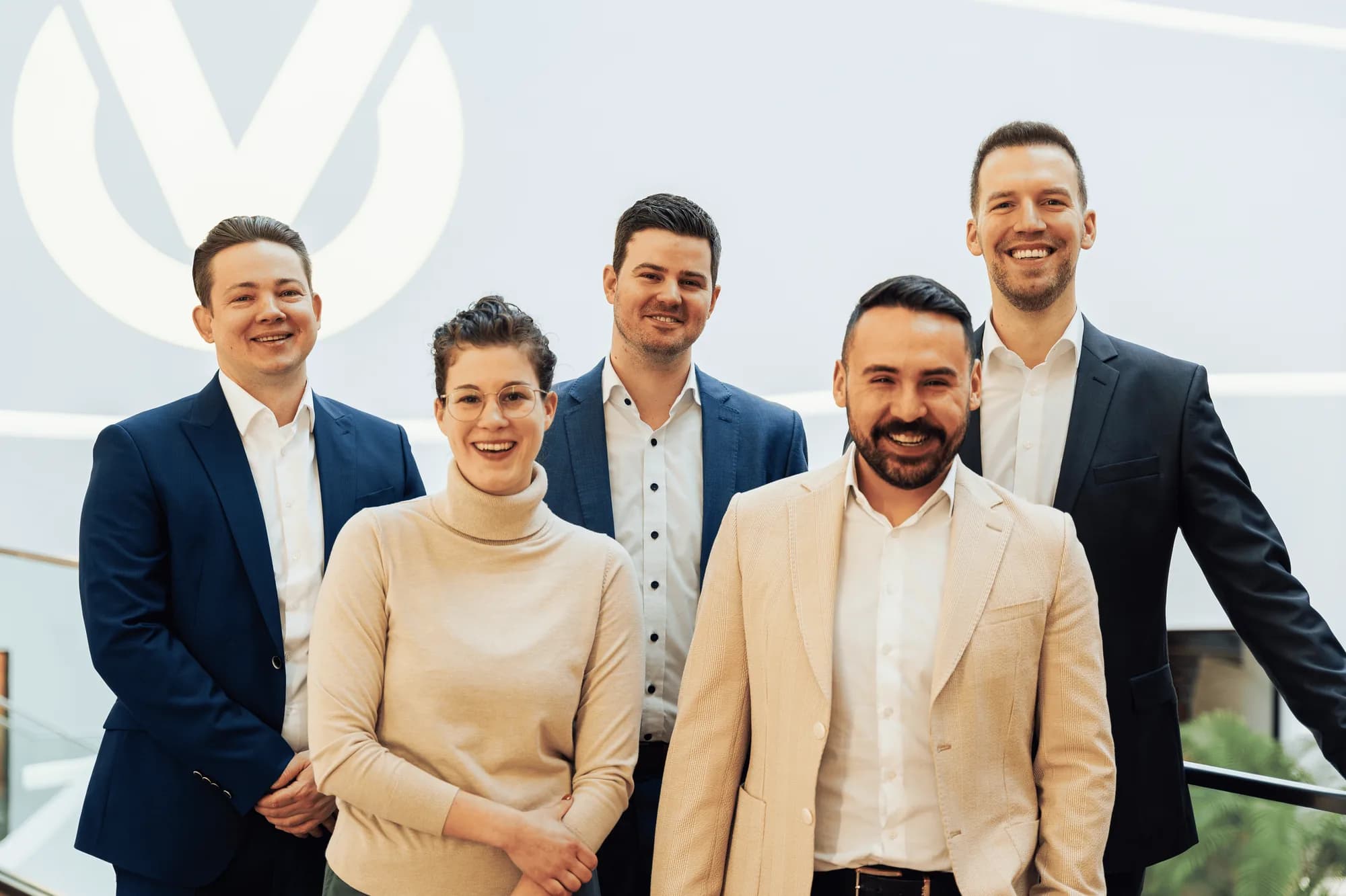 Das Team von Vermögen und Karriere vor der Logowand